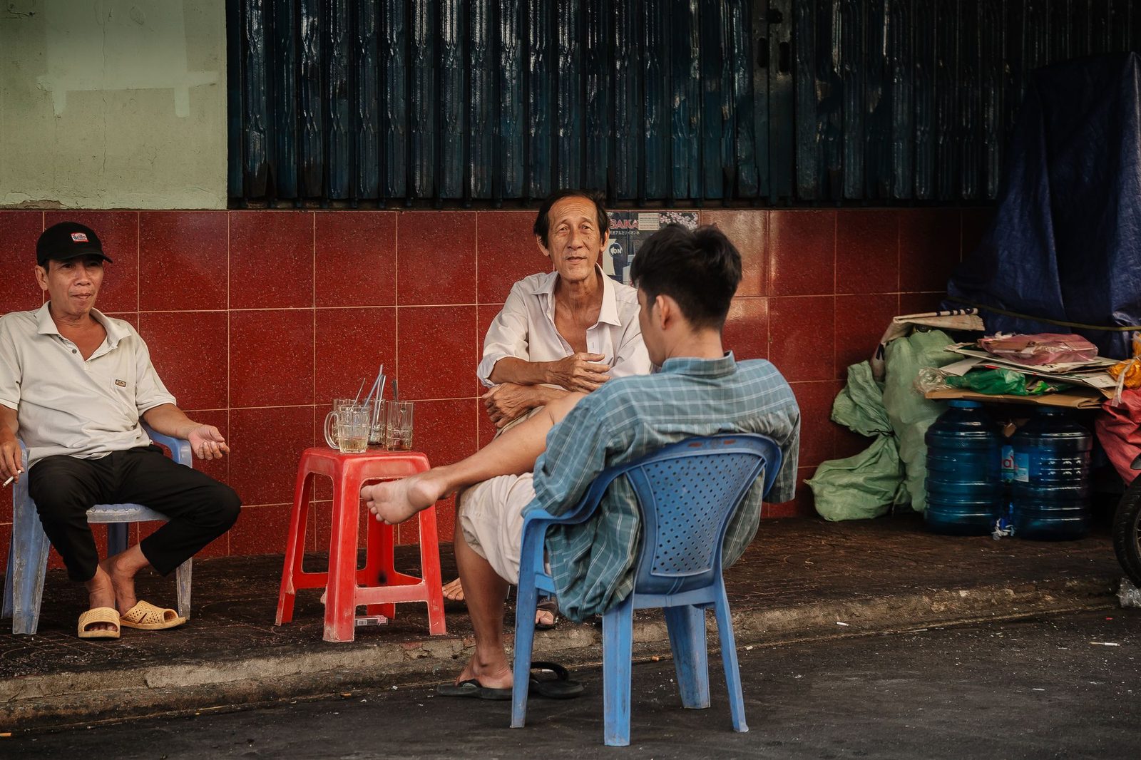 People talking on plastic stools on a Vietnamese street